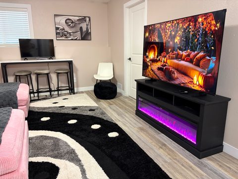 A 65-inch TV over an electric fireplace downstairs too
